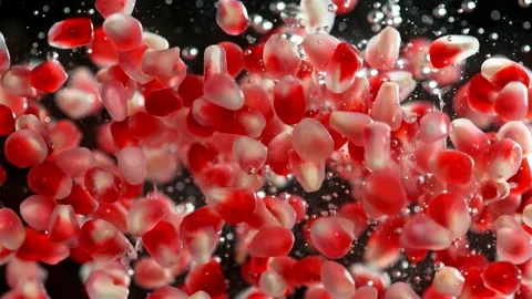 Super slow motion of falling pomegranate pieces into water. Stock Footage 212069275