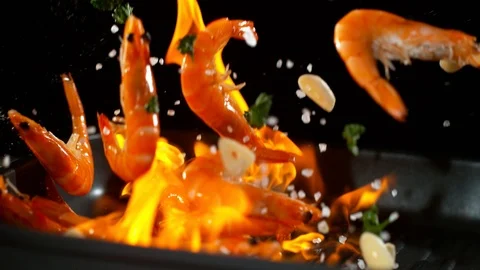 Super slow motion of falling prawns into flames Stock Footage 98661369