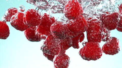 Super slow motion of falling raspberries into water on blue background. Stock Footage 207463257