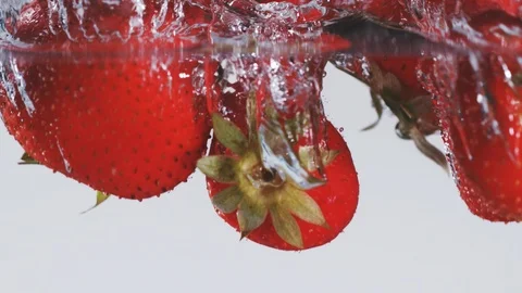 Super slow motion of falling strawberries into water. Stock Footage 90668323