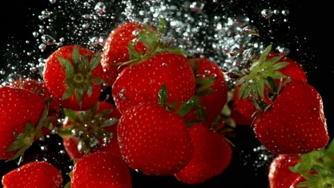 Super slow motion of falling strawberries into water on black background. Stock Footage 212020267