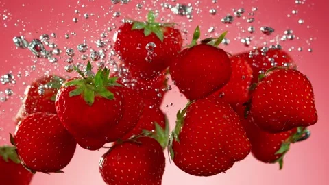 Super slow motion of falling strawberries into water on black background. Stock Footage 212020268