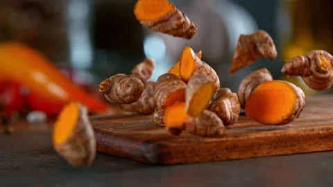 Super slow motion of falling turmeric spice on wooden board. Stock Footage 166964478