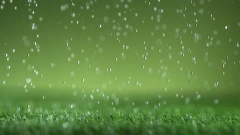 Super slow motion of falling water drops on green lawn, macro shot Stock Footage 155247444