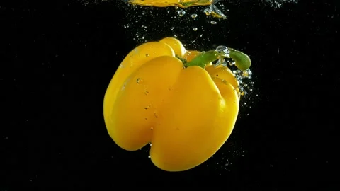 Super slow motion of falling yellow pepper underwater. Stock Footage 212010624