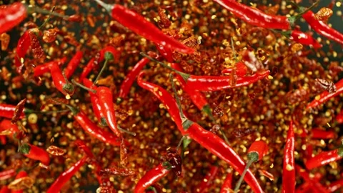 Super slow motion of flying and rotating red chilli peppers. Stock Footage 239247213
