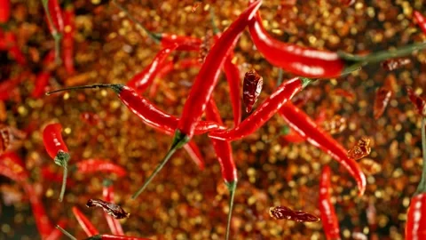 Super slow motion of flying and rotating red chilli peppers. Stock Footage 239248885