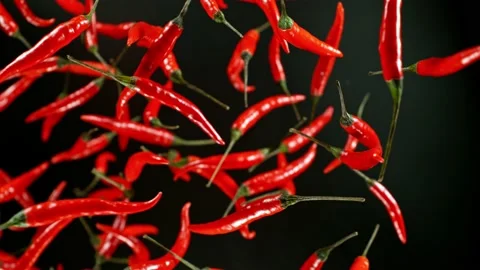 Super slow motion of flying and rotating red chilli peppers. Stock Footage 239302498