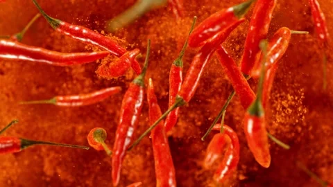 Super slow motion of flying and rotating red chilli peppers. Stock Footage 243022284