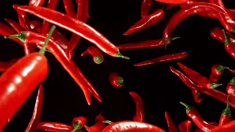 Super slow motion of flying and rotating red chilli peppers. Stock Footage 282295731