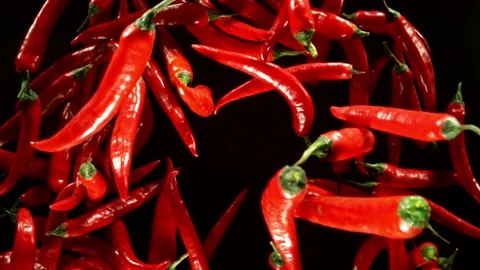 Super slow motion of flying and rotating red chilli peppers. Stock Footage 282295818