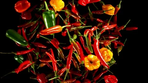 Super slow motion of flying and rotating chilli peppers. Stock Footage 282439312