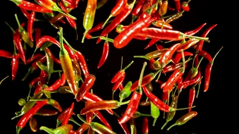 Super slow motion of flying and rotating chilli peppers. Stock Footage 282439383