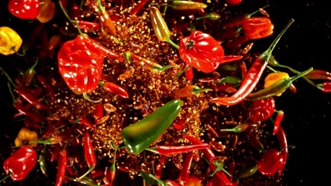 Super slow motion of flying and rotating chilli peppers. Stock Footage 282439384