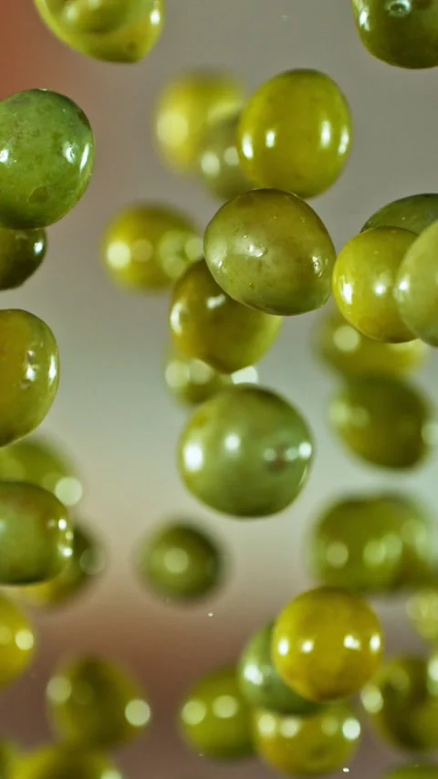 Super Slow Motion of Flying and Rotating Green Olives. Stock Footage 310945517
