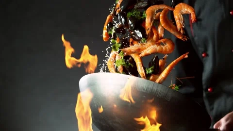Super slow motion of flying chilli peppers and prawns from wok pan Stock Footage 130863374