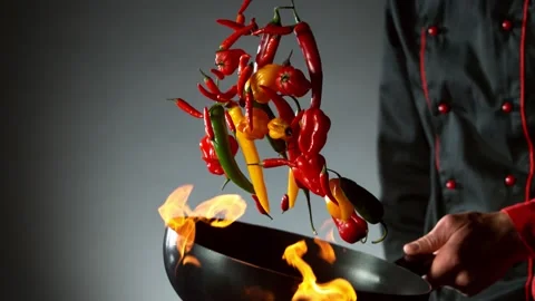 Super slow motion of flying chilli peppers from wok pan, chef closeup. Stock Footage 130873110