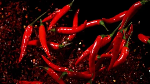 Super slow motion of flying dry and fresh red hot chilli peppers. Video stock 120511365