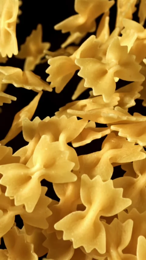 Super slow motion flying dry farfalle pasta . Filmed on a high-speed camera at Stock Footage 335378971