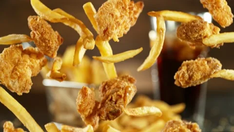Super slow motion of flying fried chicken pieces with french fries Stock Footage 236584727