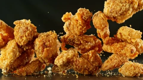 Super slow motion of flying fried chicken pieces on black background Stock Footage 236585465