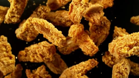 Super slow motion of flying fried chicken pieces on yellow background Stock Footage 244402457