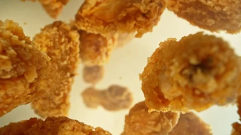 Super Slow Motion of Flying Fried Chicken Piecers on Golden Background. Stock Footage 260230939