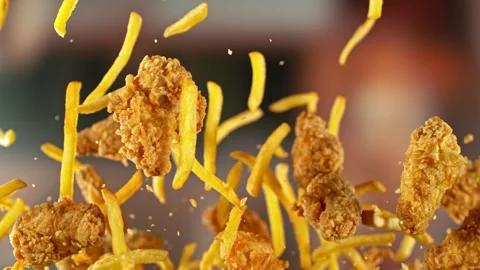 Super Slow Motion of Flying Fried Chicken Wings and French Fries. Stock Footage 306654127
