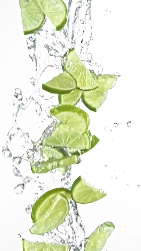 Super Slow Motion of Flying Lime Slices in Water Splashes, White Background Stock Footage 303372436
