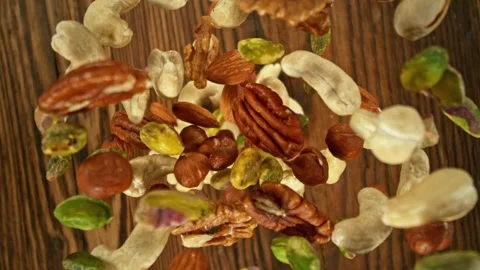 Super Slow Motion of Flying Nuts Mix over Wooden Planks. Stock Footage 274444971