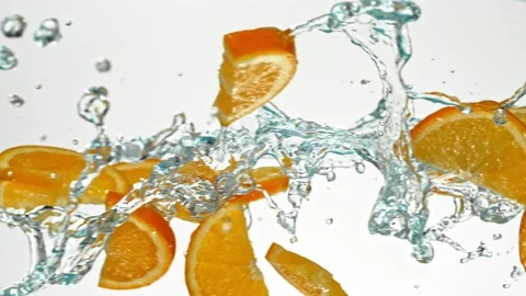Super Slow Motion of Flying Orange Slices in Water Splashes, White Background. Stock Footage 303371063