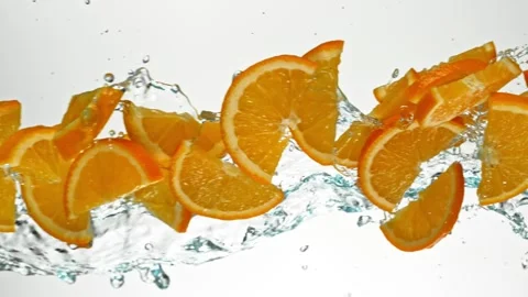 Super Slow Motion of Flying Orange Slices in Water Splashes, White Background. Stock Footage 303372210