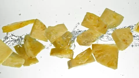 Super Slow Motion of Flying Pineapple Slices in Water Splashes. Stock Footage 303372209