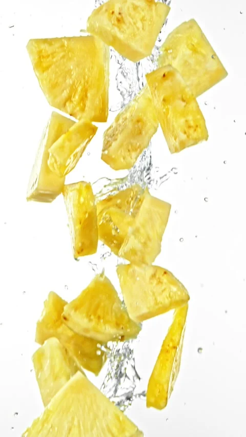 Super Slow Motion of Flying Pineapple Slices in Water Splashes, White Background Stock Footage 303372423