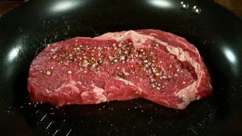 Super Slow Motion of Flying Raw Beef Steak on Pan. Stock Footage 284350497