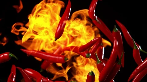 Super slow motion of flying red hot chilli peppers in fire. Stock Footage 115022387