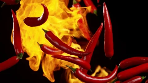 Super slow motion of flying red hot chilli peppers in fire with speed ramping Stock Footage 118977679