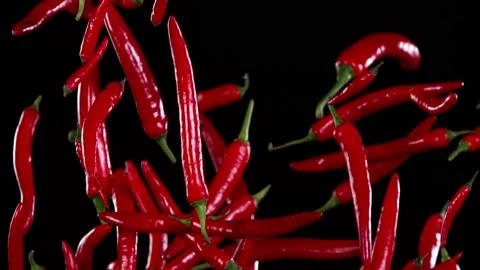 Super slow motion of flying red hot chilli peppers. Stock Footage 163787404
