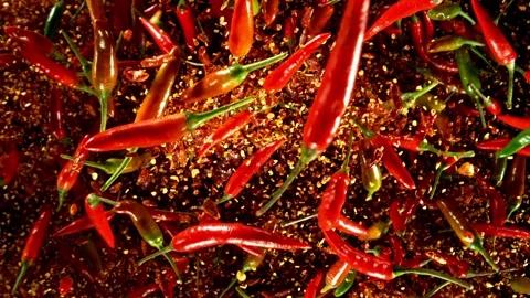 Super slow motion of flying red hot chilli peppers isolated on black background. Stock Footage 304511753