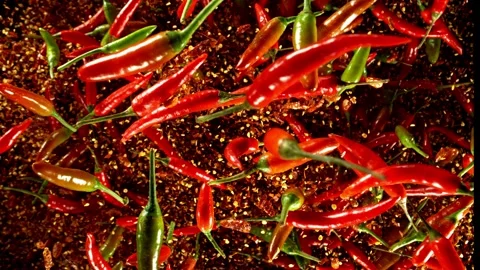 Super slow motion of flying red hot chilli peppers isolated on black background. Stock Footage 312651239
