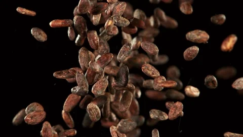 Super slow motion of flying roasted cocoa beans in collision, black background Stock Footage 136755944