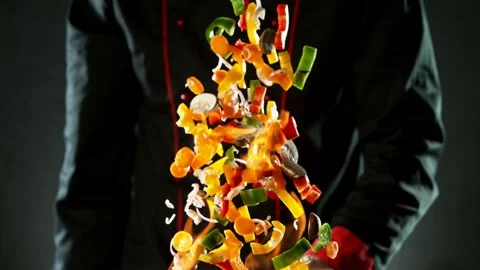 Super slow motion of flying sliced vegetable pieces from wok pan Stock Footage 130872854