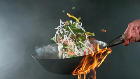 Super slow motion of flying sliced vegetable and noodles from wok pan. Stock Footage 168831166