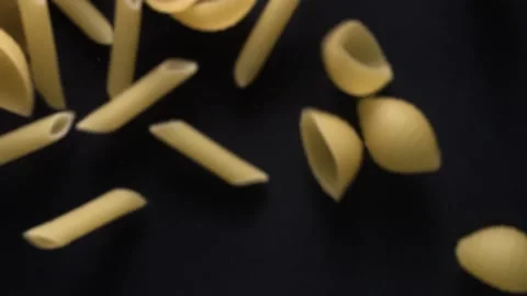 Super slow motion of flying uncooked italian pasta on black background. Stock Footage 151085444