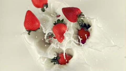 The super slow motion of the fragrant strawberry falls with splashes in the milk Vídeo Stock 157344654