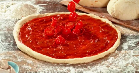 Super slow motion fresh sliced tomatoes falling into tomato sauce on pizza dough Stock Footage 328819533