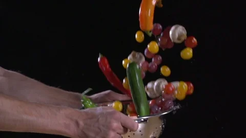 Super slow motion. fruit and vegetables flying out of colander. Water drops.  Stock Footage 80548194