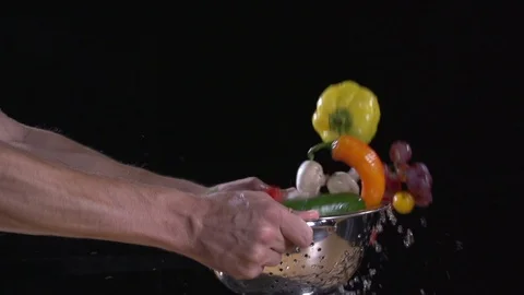 Super slow motion. fruit and vegetables flying out of colander. Water drops.  Stock Footage 80548268