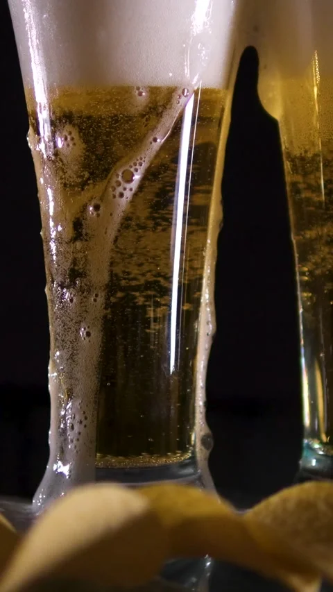 Super slow motion a glass of cold beer on a table in a black background, Potato Video stock 302074653