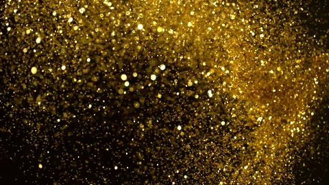 Super slow motion of glittering golden particles on black background, low dof Stock Footage
